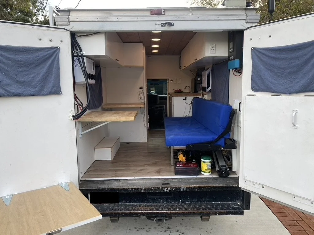 Rear partially folded out. Couch folds down into a bed. Rear doors have folding rear tables.